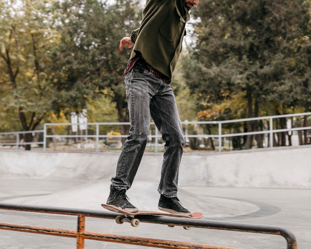 Foto uomo con skateboard fuori nel parco cittadino