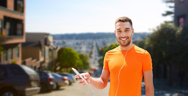 man with smartphone and earphones in san francisco