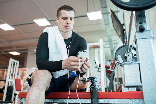 Uomo con lo smartphone in palestra