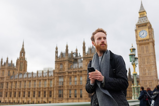 ロンドンの通りでスマートフォンを持つ男