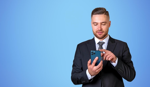 Man with smartphone near blue wall