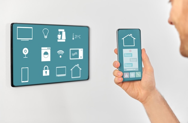 man with smartphone and tablet pc at smart home