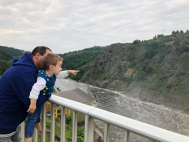 Foto uomo con figlio che guarda il fiume