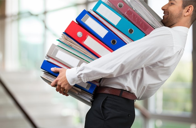 Man with stack of folders with documents on background