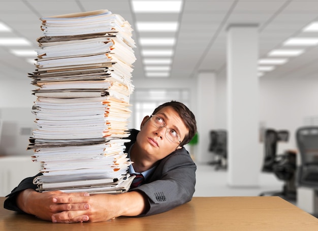 Man with stack of folders with documents on background