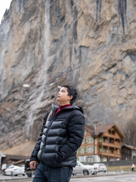 Man with Staubbach Falls Kirche nature during winter in Lauterbrunnen Switzerland