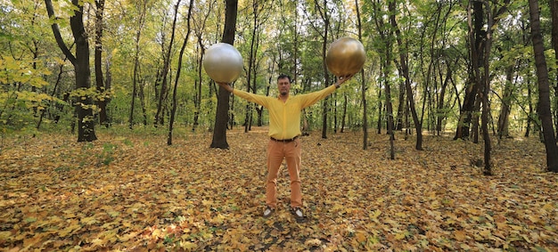 man with a strange golden ball head in the forest