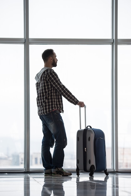 Man with a suitcase waiting for his flight.