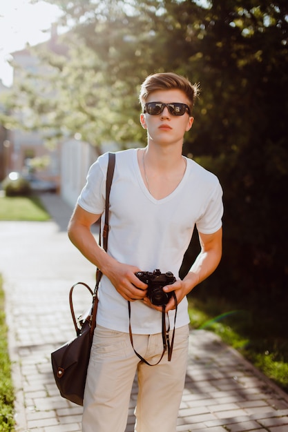 Man with sunglasses with a reflex camera in hands