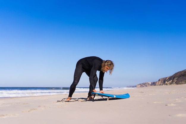 man with surf board on the ocean shore. Surfer in a wet suit