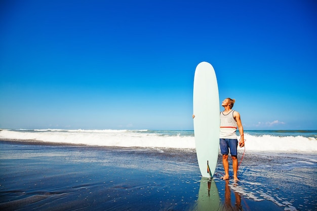 Man with surfboard on a beach