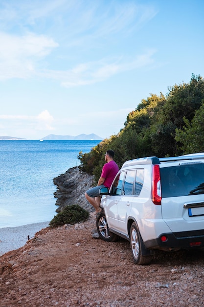 Man with suv car at sea beach road trip greece lefkada