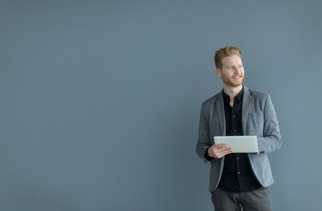 Man with tablet by the wall