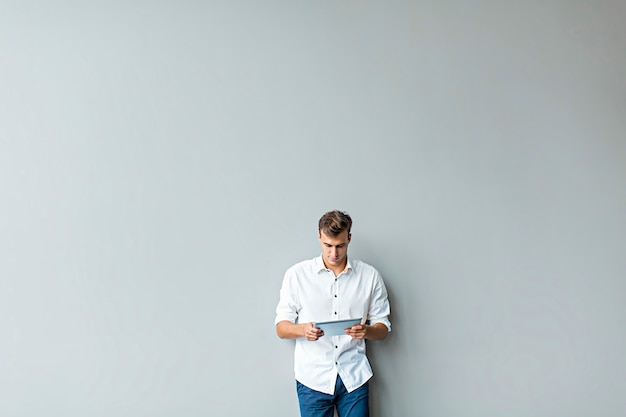 Man with tablet by the wall