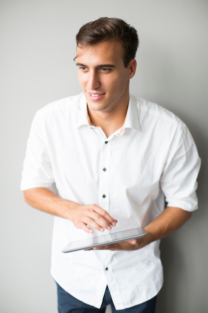 Man with tablet by the wall