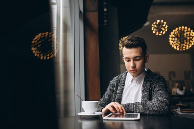 Uomo con tablet e caffè in un caffè