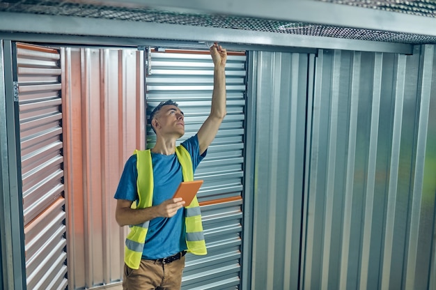 Man with tablet correcting detail on ceiling