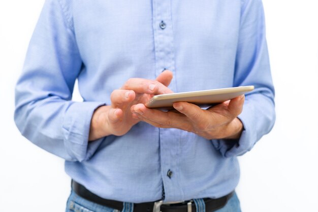 Man with tablet in hands and blue shirt on white background. Copy space.