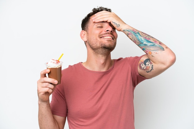 A man with tattoos on his arm holds a chocolate ice cream.