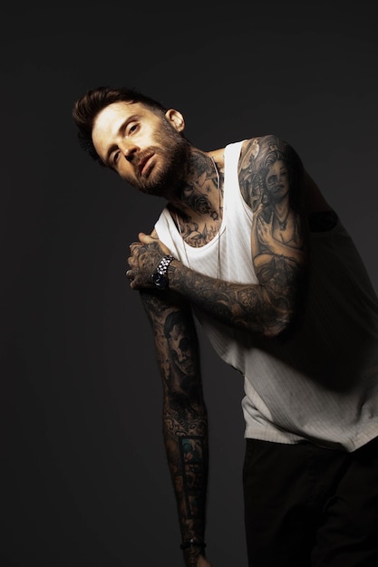 Photo a man with tattoos on his arms