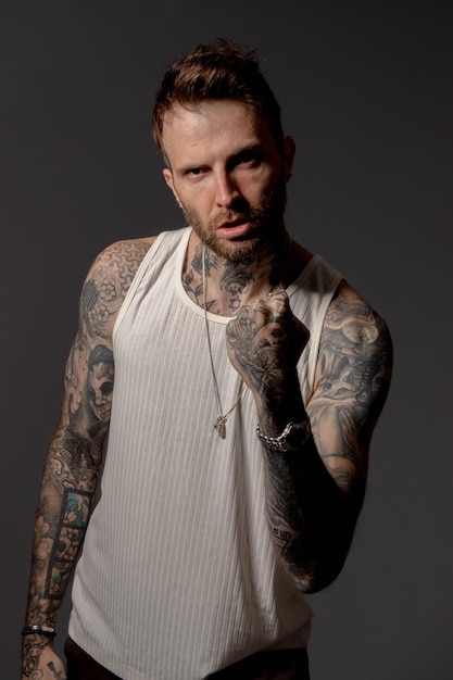 Photo a man with tattoos on his arms