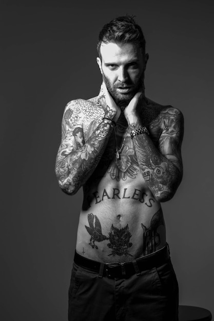 Foto un uomo con dei tatuaggi con su scritto 