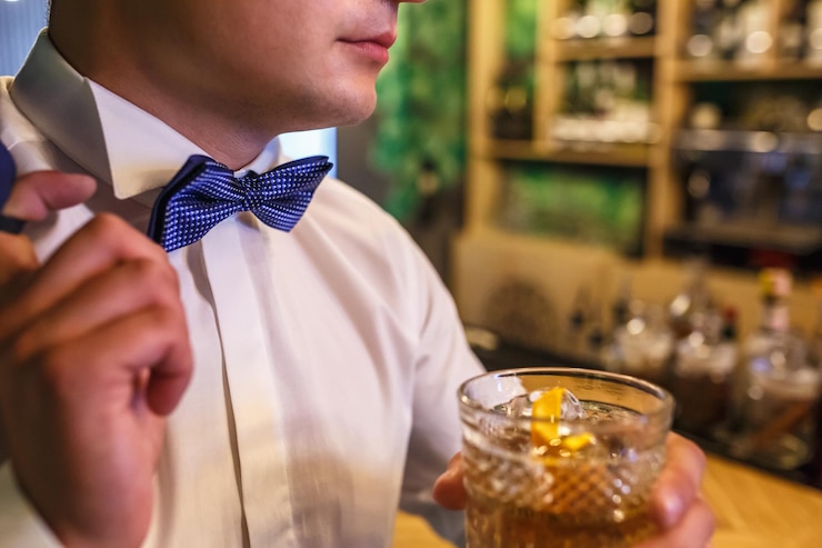 Photo man with a tie and a glass of whiskey in his hands in a trendy bar