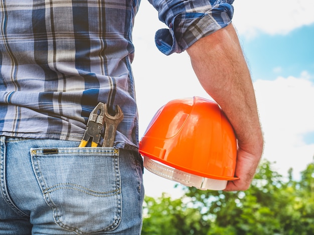 Man with tools holding a safety helmet