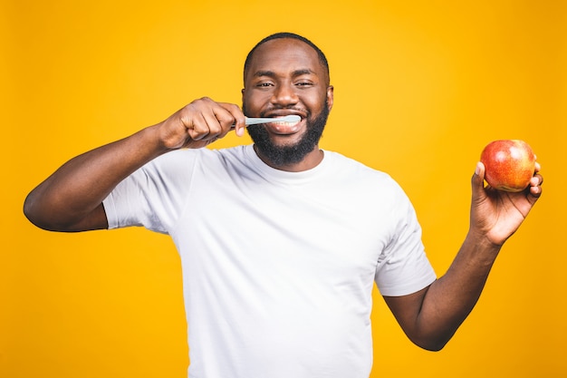 Man with tooth brush. Image of young shirtless African man holding a toothbrush with toothpaste and apple, smiling