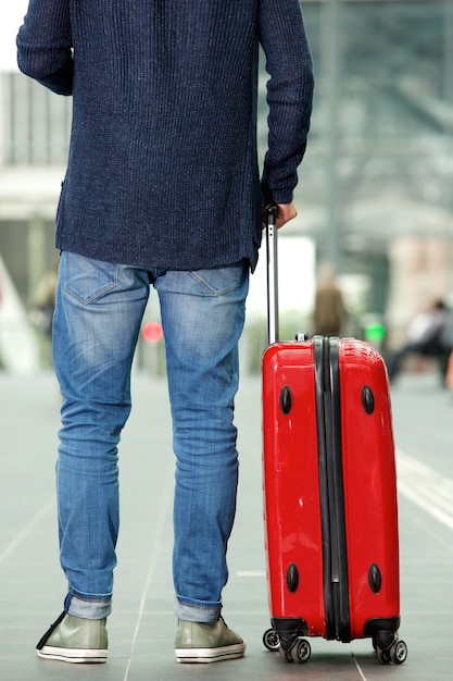 Man with traveling bag standing at train station