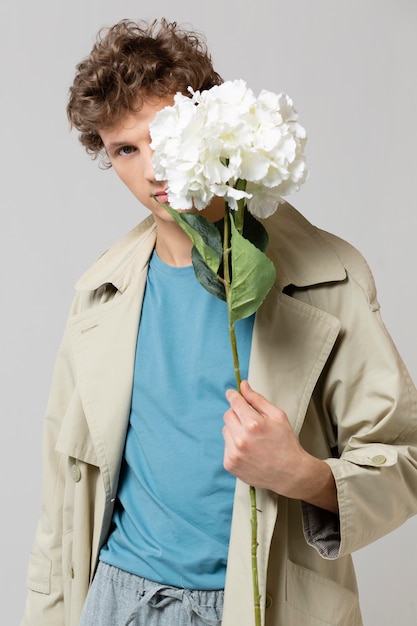 Photo man with trench coat holding flowers