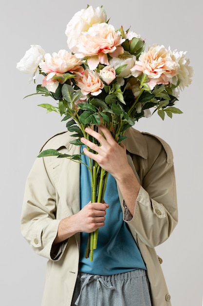 Photo man with trench coat holding flowers