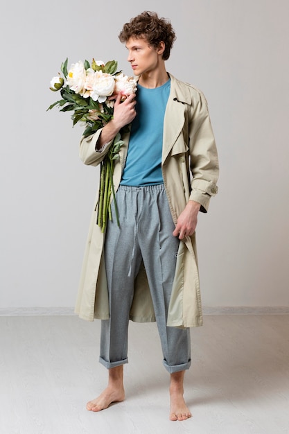 Photo man with trench coat holding flowers