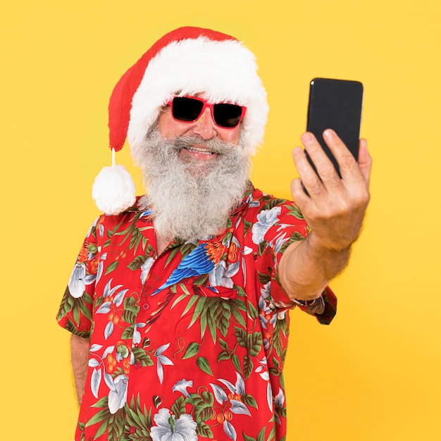 写真 トロピカルシャツとコピースペースのクリスマス帽子を持つ男