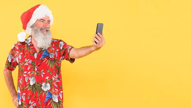 Foto uomo con camicia tropicale e cappello di natale con copia spazio