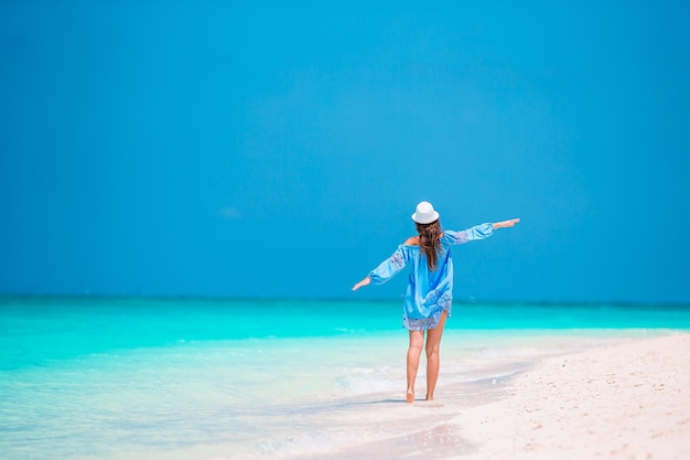 Man with umbrella on beach against blue sky