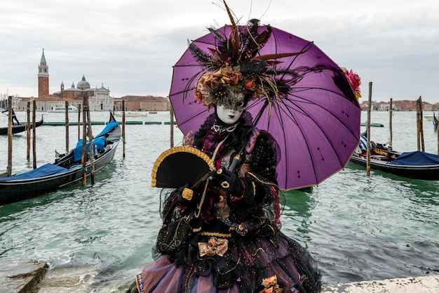 Uomo con ombrello su una barca nel canale