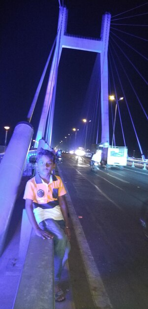 Man with umbrella on road in city at night