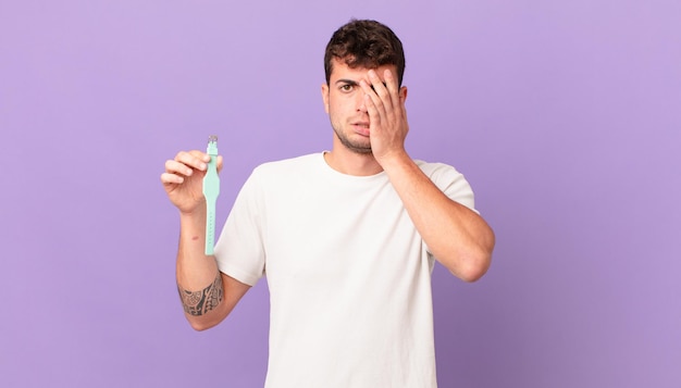 Man with a watch feeling bored, frustrated and sleepy after a tiresome, dull and tedious task, holding face with hand