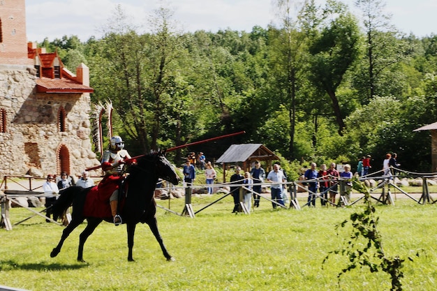 Foto uomo con un'arma a cavallo sull'erba