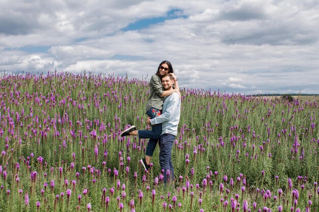 A man with a woman walking in the park with flowers in the summer on a clear day