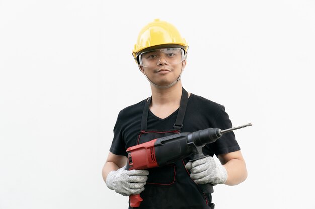 Man with yellow helmet and drilling machine