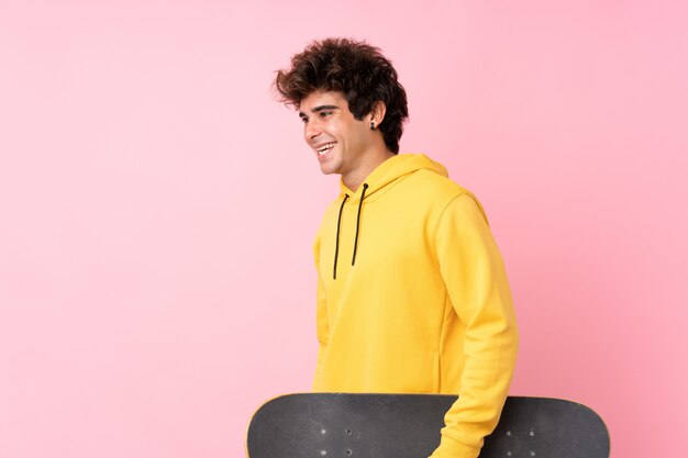黄色のパーカーとスケートボードを持つ男
