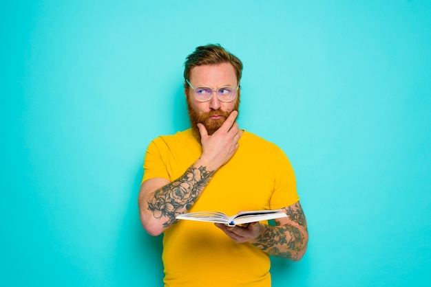 Man with yellow tshirt reads a book