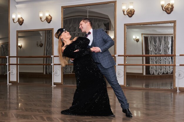 Man and woman amateur dancers laugh during classical dance with each other