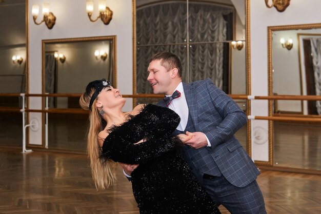 Man and woman amateur dancers laugh during classical dance with each other