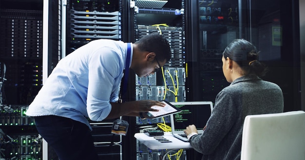 Man woman and team with server programming and laptop with support for IT solution at company People maintenance and hardware check with tablet app or information technology for coding project