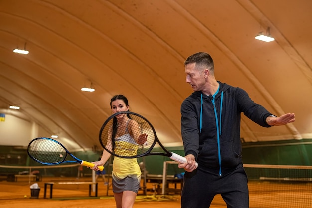 Man and a woman are fooling around on the tennis court