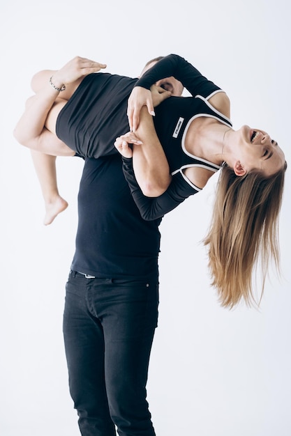 A man and woman are holding up a woman in a black t - shirt.