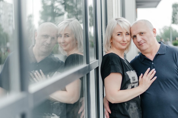 a man and a woman are hugging near a window in the city